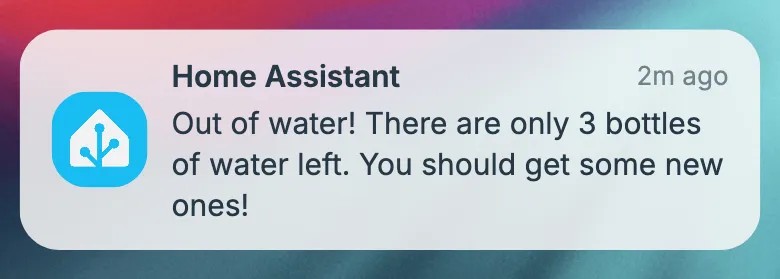 Mobile push notification from Home Assistant with the blue Home Assistant logo, reading "Out of water! There are only 3 bottles of water left. You should get some new ones!", timestamped 2 minutes ago, displayed on a blurred colorful background