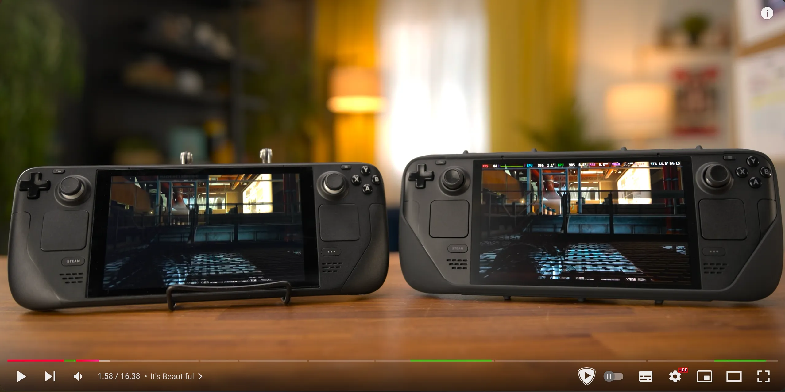 YouTube video player showing two Steam Deck devices side by side on a wooden table, with green sponsor block markers visible on the video progress bar at the bottom of the screen.