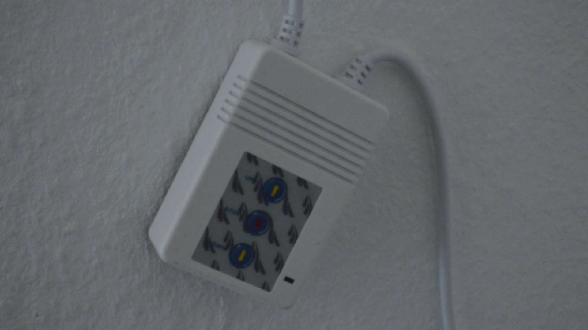 The controller to control the screen: A plastic box with three buttons, up, stop and down.